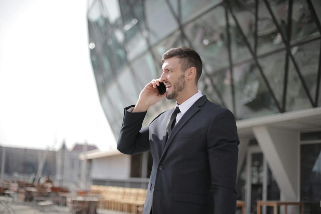 Professional man in suit using smartphone outdoors in urban corporate setting.